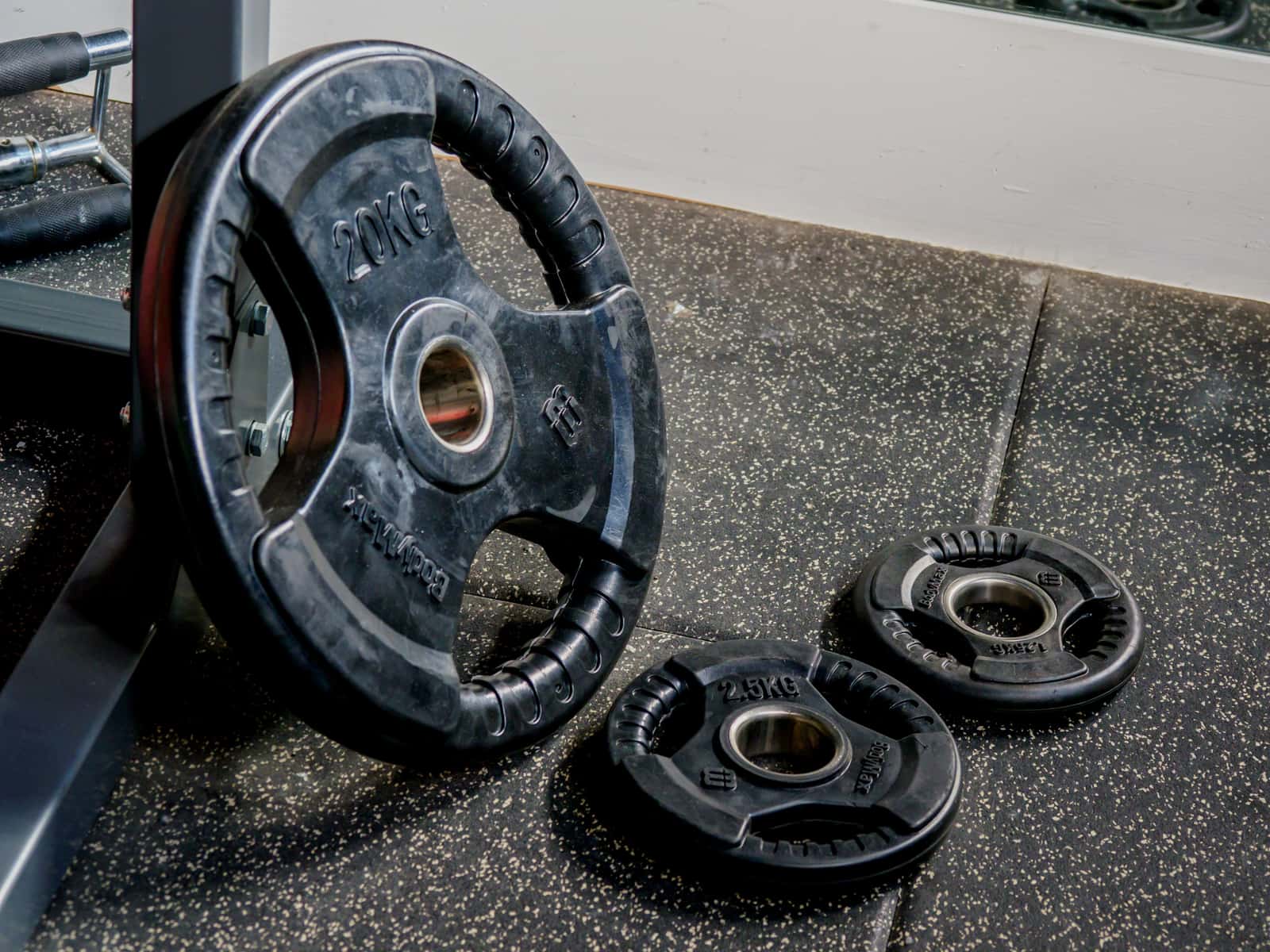 Weight plates and a barbell on a gym floor
